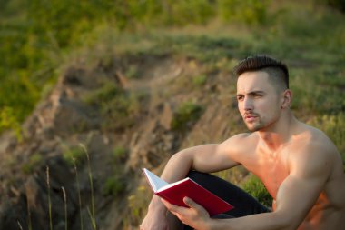 Kitap açık olan dalgın kaslı adam