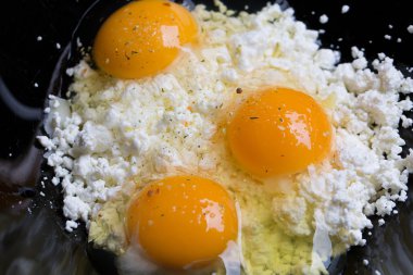 Süzme peynir üzerinde kırık yumurta