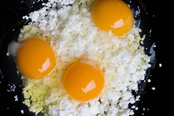 Broken eggs on cottage cheese — Stock Photo, Image