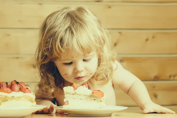 Küçük çocuk çilekli kek yiyor — Stok fotoğraf