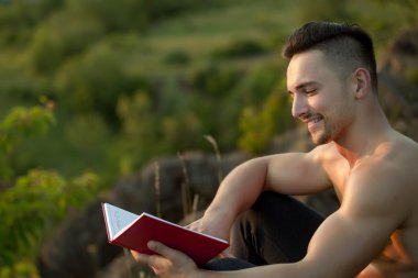 Kitap açık ile gülümseyen kaslı adam