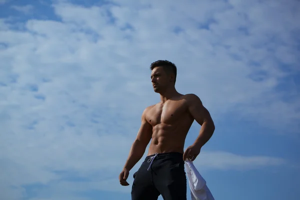 在天空背景上脱衣服的性感肌肉男 — 图库照片