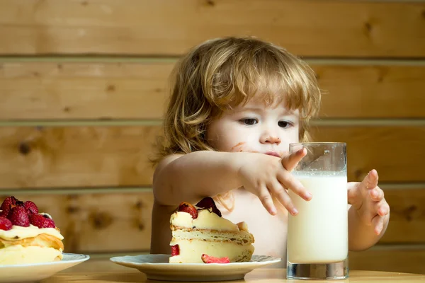 Маленький мальчик с клубничным тортом и йогуртом — стоковое фото
