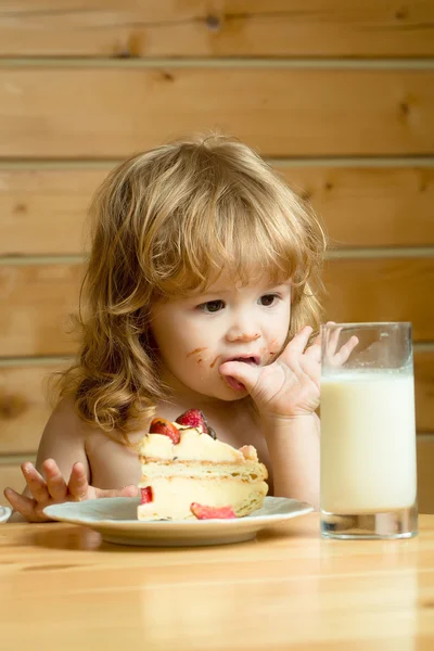 Mały chłopiec z ciastem truskawkowym i jogurtem — Zdjęcie stockowe
