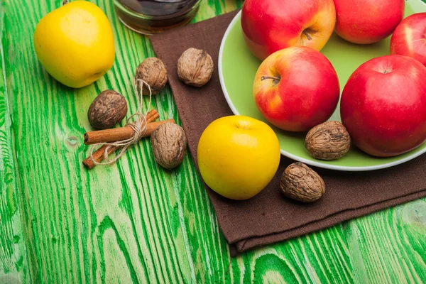 Ořechové jablka a skořice na zelené dřevo — Stock fotografie