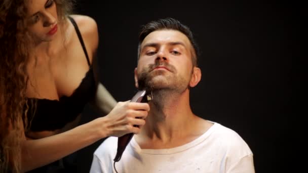 Sexy barber girl trimming a beard of a man — Stock Video