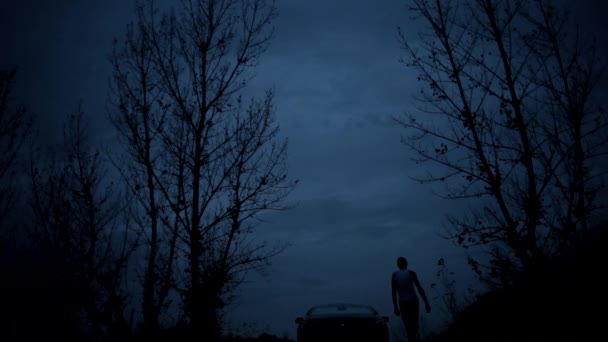 Самотній хлопець в лісі вночі — стокове відео