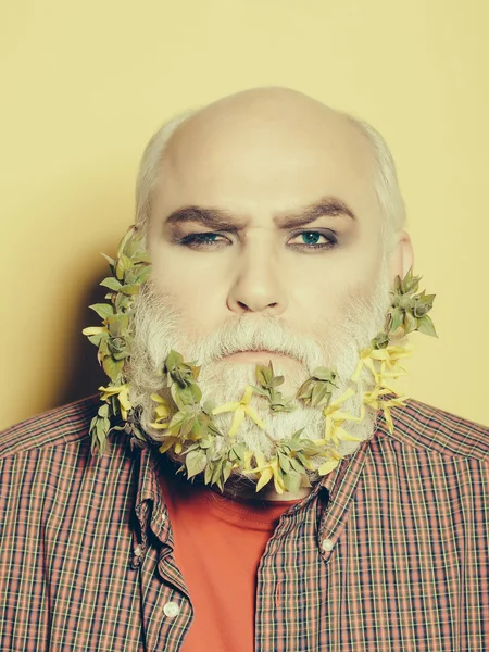 Anciano con flores y hojas en barba — Foto de Stock
