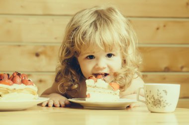 küçük çocuk çilekli kek yiyor