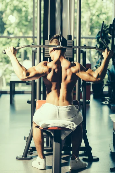 Musculoso hombre entrenamiento en gimnasio —  Fotos de Stock