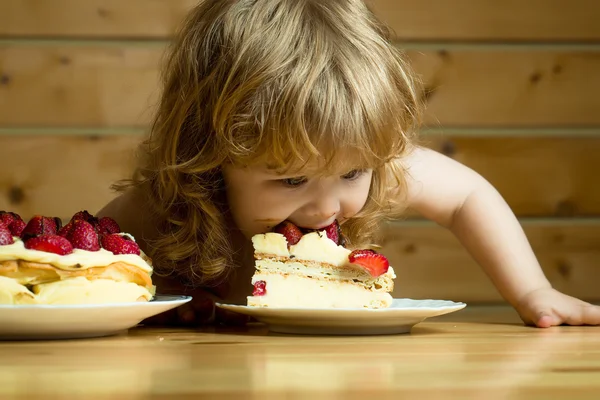 Kleine jongen eet aardbeien cake — Stockfoto