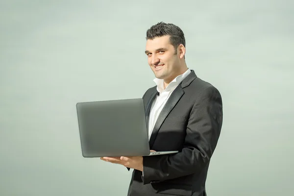 Бизнесмен с ноутбуком на открытом воздухе — стоковое фото