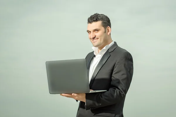 Zakenman met laptop buiten — Stockfoto