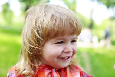 Yeşil doğal zemin üzerine mutlu küçük çocuk