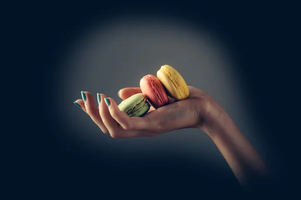 Vrouwelijke handen met macaron — Stockfoto