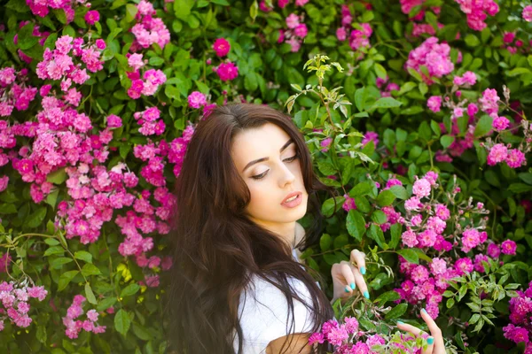 Mujer cerca de rosal rosa — Foto de Stock