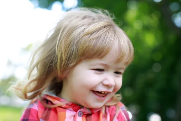 Glad liten pojke på grön naturliga bakgrund — Stockfoto