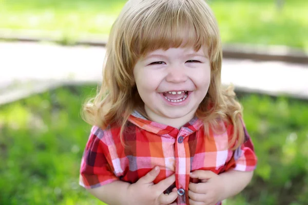 緑の芝生の上の幸せの小さな男の子 — ストック写真
