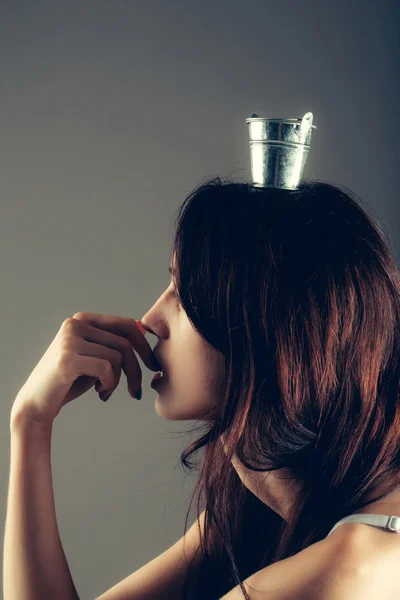 Young woman with small pail on head — Stockfoto