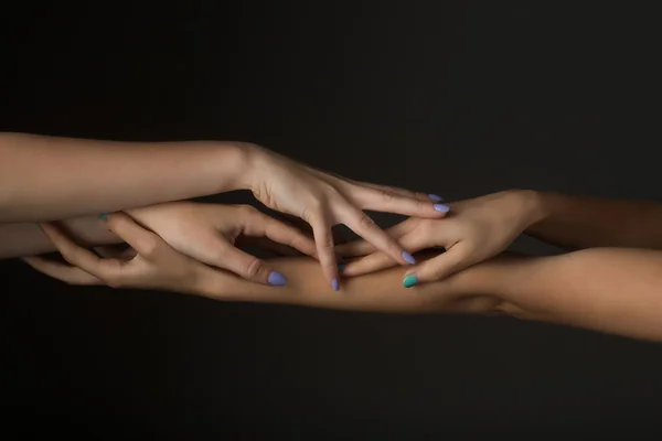Quatro mãos femininas tocando — Fotografia de Stock