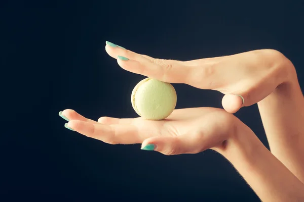 Vrouwelijke handen met macaron — Stockfoto