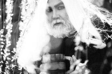 Kupa çiçek ile sakallı adam