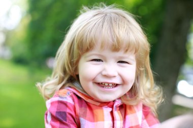 Yeşil doğal zemin üzerine mutlu küçük çocuk