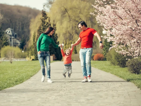 Glückliche Familie im blühenden Park — Stockfoto