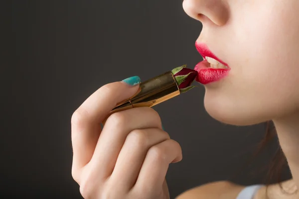 Manos femeninas con lápiz labial de rosa roja — Foto de Stock