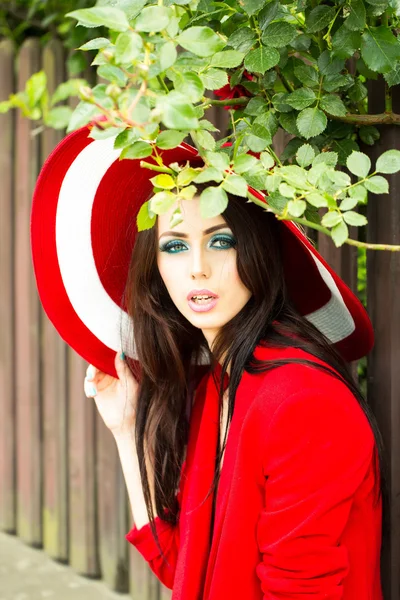 Sexig kvinna i röd hatt med ros — Stockfoto