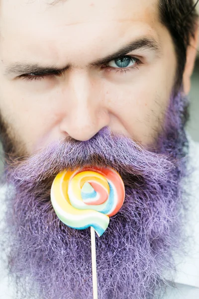 Bebaarde man met blauwe baard en lolly — Stockfoto