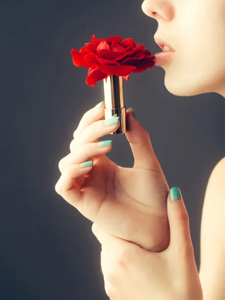 Manos femeninas con lápiz labial de rosa roja — Foto de Stock