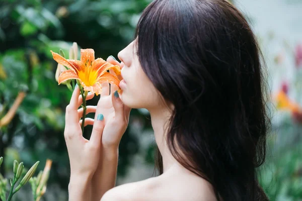 Жінка любить помаранчеву квітку лілії — стокове фото