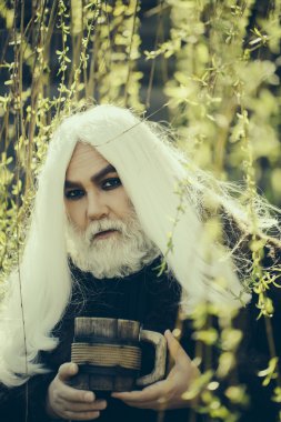 Kupa çiçek ile sakallı adam