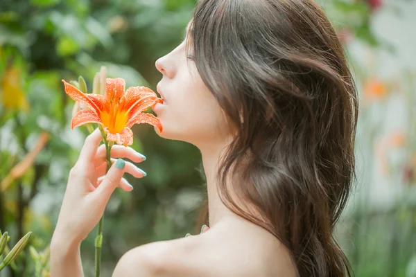 Woman enjoys orange lily flower — Stock Photo, Image