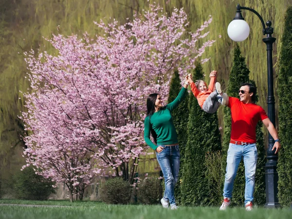 Glückliche Familie im blühenden Park — Stockfoto