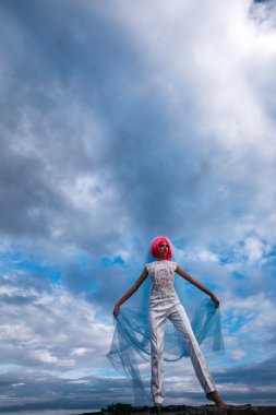 Mavi gökyüzü üzerinde turuncu saçlı gelin