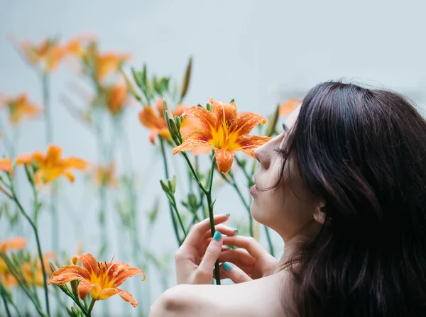Mulher gosta de flor de lírio laranja — Fotografia de Stock