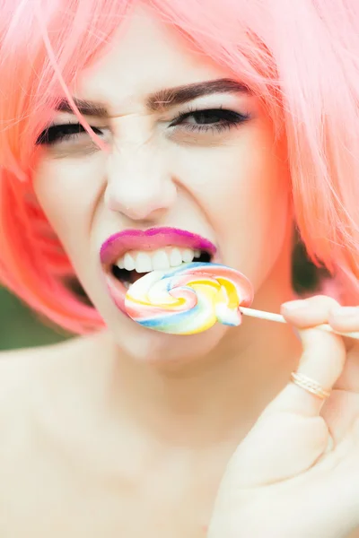 woman with orange hair lick lollipop