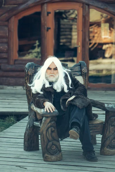 Vecchio mago in sedia di legno — Foto Stock