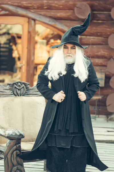 Oude wizard in houten stoel — Stockfoto