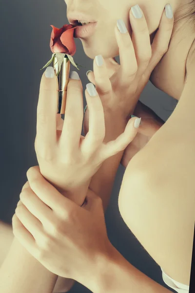 female hands with red rose lipstick