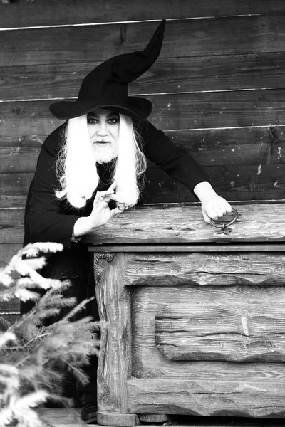 Velho feiticeiro perto de caixa de madeira no peito ou tronco — Fotografia de Stock