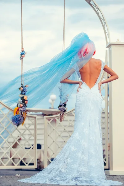 Mariée avec voile bleu près de swing — Photo