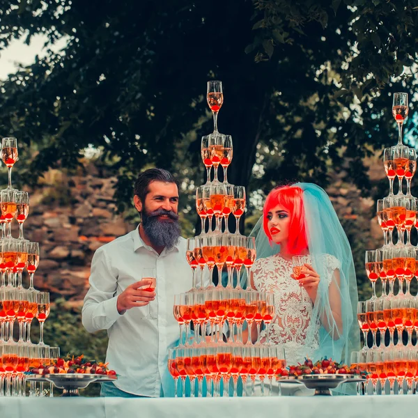 Wedding couple with pyramids of wine glasses outdoor — Stock Photo, Image