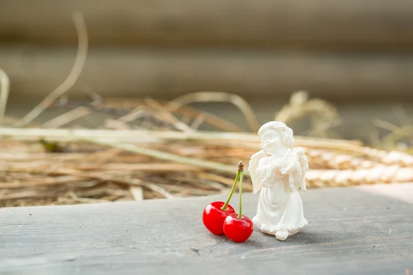 Cereza sobre tabla de madera con ágel de San Valentín —  Fotos de Stock