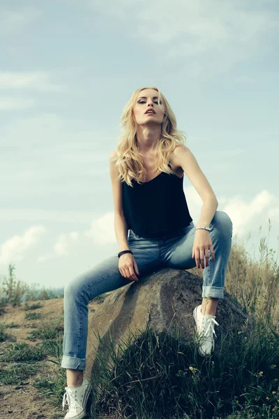 Jolie femme sur pierre et ciel bleu — Photo