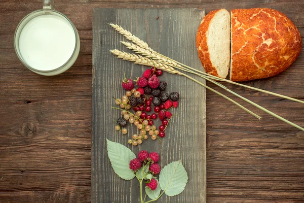 Bread wild berries and cup of milk — Stock Photo, Image