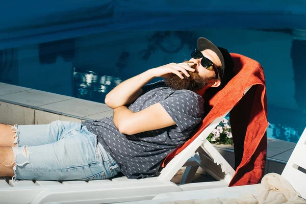 Homme barbu en lunettes de soleil à la piscine — Photo