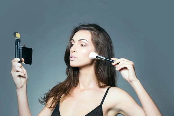 Kobieta w biustonosz z makijażu pędzel i lustro — Zdjęcie stockowe